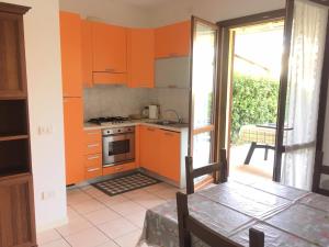 a kitchen with orange cabinets and an open door at Gugliormella in Sirolo