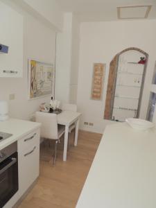 eine weiße Küche mit einem Tisch und einem Stuhl in der Unterkunft Casa nei pressi del Duomo,Firenze centro storico in Florenz