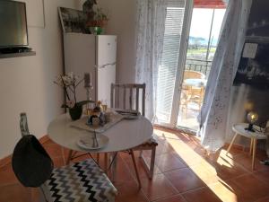 a table and chairs in a room with a refrigerator at Guesthouse Porec in Poreč