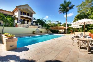 una piscina con patio y una casa en San Ignacio Resort Hotel en San Ignacio