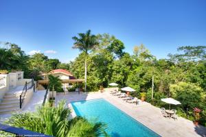 una piscina con sedie e ombrelloni in un cortile di San Ignacio Resort Hotel a San Ignacio