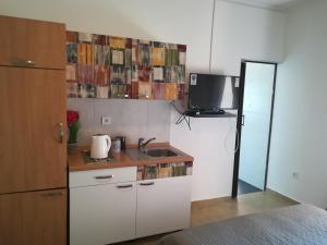 a kitchen with a sink and a tv on the wall at Guesthouse Porec in Poreč