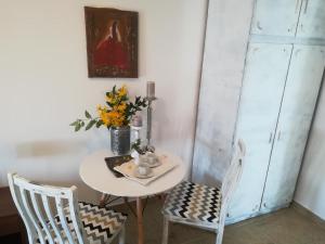 a table with two chairs and a vase with flowers at Guesthouse Porec in Poreč