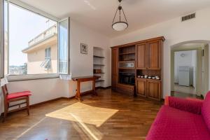 een woonkamer met een rode bank en een raam bij JOIVY Apartment for 4 near the Port of Genoa in Genua