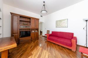 ein Wohnzimmer mit einem roten Sofa und einem TV in der Unterkunft JOIVY Apartment for 4 near the Port of Genoa in Genua
