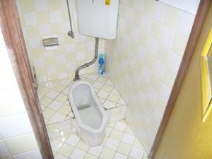 a small bathroom with a urinal in a stall at Kofuji Ryokan in Kurashiki