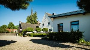 a white house with a church in the background at Pension Kerckenhof in Xanten