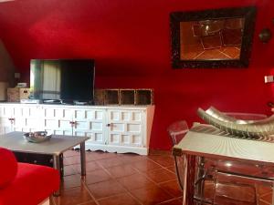 a living room with a red wall and a tv at Duplex La Cala in Cala del Moral