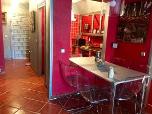 eine Küche mit roten Wänden und einem Tisch und Stühlen in der Unterkunft Duplex La Cala in La Cala del Moral