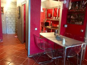 a kitchen with red walls and a table and chairs at Duplex La Cala in Cala del Moral