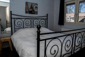 a bedroom with a black and white bed and a window at Chaletparc Krabbenkreek Zeeland - Chalet 50 in Sint Annaland