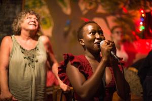 un hombre y una mujer cantando en un micrófono en un escenario en Blend Lodge and Kitchen - Pakachere, en Zomba
