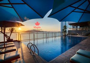 
a pool with umbrellas in the middle of it at Maple Hotel & Apartment in Nha Trang

