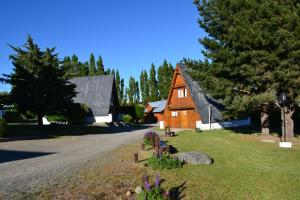 a house on the side of a road with trees at Cabañas Nevis, excelente ubicación in El Calafate