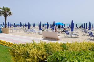 einen Strand mit Liegestühlen und Sonnenschirmen und dem Meer in der Unterkunft Beach Jesolo apartment in Lido di Jesolo