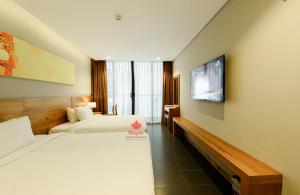 
a hotel room with a television and a bed at Maple Hotel & Apartment in Nha Trang
