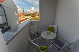 balcón con mesa, sillas y ventana en Apartman Mar, en Nin