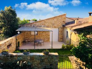 a stone house with a patio in a yard at GITE L'ATELIER in Palus