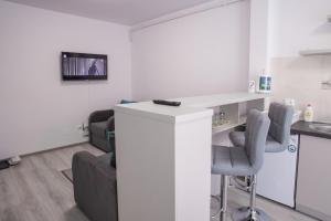 een kamer met een aanrecht, stoelen en een tafel bij Apartament Turcoaz in Sibiu