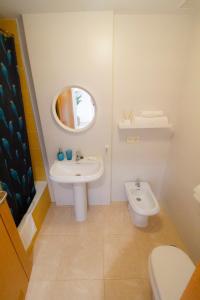 W łazience znajduje się umywalka, toaleta i lustro. w obiekcie MEDANO4YOU Pearl Flavour Holiday Home w mieście El Médano