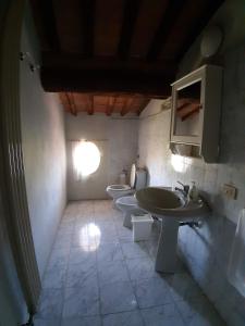 a bathroom with three sinks and two toilets at B&B Glicine e Luna in Cascina