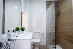 a white bathroom with a toilet and a shower at APARTAMENTOS OASIS in Zamora +34 photos