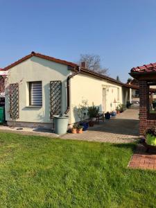 una casa blanca con plantas en un patio en Ferienwohnung Simone, en Senftenberg