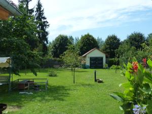 a garden with a small building in the background at Ferienwohnung Simone in Senftenberg