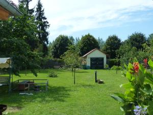 einen Garten mit einem kleinen Gebäude im Hintergrund in der Unterkunft Ferienwohnung Simone in Senftenberg