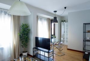 a living room with a television and a glass table at APARTAMENTOS OASIS in Zamora