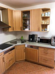 a kitchen with wooden cabinets and a counter top at Ferienwohnung Simone in Senftenberg