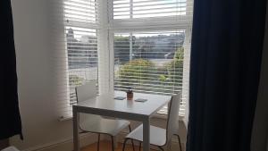 een witte tafel en twee stoelen voor een raam bij Saltwater in St Ives