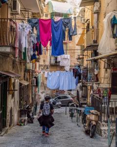 a child walking down a street with clothes hanging from a clothes line at Toledo Loft in Naples