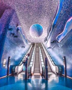 an escalator in a building with a purple ceiling at Toledo Loft in Naples