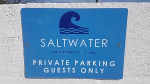 a sign on a wall that reads saltwater private parking guests only at Saltwater in St Ives