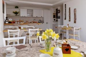 een keuken en eetkamer met een tafel met gele bloemen bij Bike Bed&Breakfast Mille Pini in Baselga di Pinè