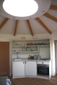 uma cozinha com um lavatório e uma grande luz em Skye Cabins em Skeabost