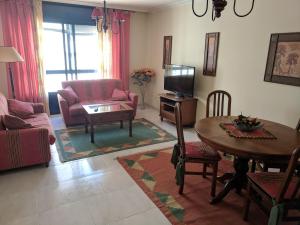 a living room with a table and chairs and a television at L&C Codesal in Sanxenxo