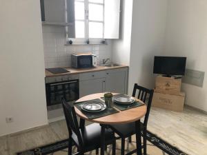 a small kitchen with a table and chairs in a room at Mouraria House - Casa de Charme - Centro Histórico in Évora