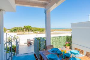 Una mesa de comedor en un balcón con vista al mar. en Villa Laura vista mare, en Torre Santa Sabina