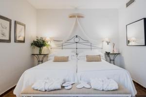 1 dormitorio con 2 camas, sábanas blancas y toallas en Palacio De Los Navas, en Granada