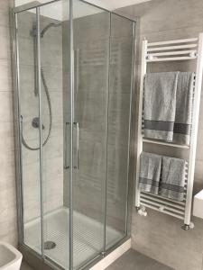uma cabina de duche em vidro na casa de banho com toalhas em Feel@Home Apartment+Rooms em Milão