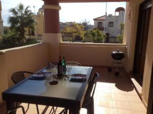 una mesa con vasos y botellas en el balcón en Costa Esuri Ayamonte Apartment, en Ayamonte