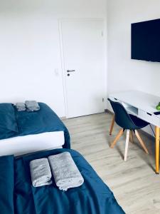 sypialnia z łóżkiem, biurkiem i stołem w obiekcie Boardinghouse BeOne w mieście Villingen-Schwenningen