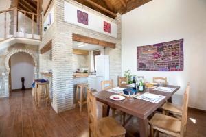 Villa fuente redonda في بارباتي: مطبخ وغرفة طعام مع طاولة وكراسي خشبية
