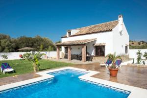 une villa avec une piscine en face d'une maison dans l'établissement Villa fuente redonda, à Barbate