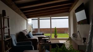 a living room with a couch and a large window at PortoHouse in Portomarin