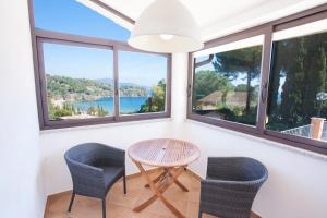 a room with windows and a table and chairs at Residenza il Gabbiano in Capoliveri