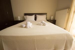 een slaapkamer met een bed met handdoeken erop bij Stasa Luxury Apartments in Keramotí