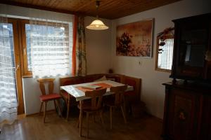 a dining room with a table and chairs and a television at Haus Waldblick in Weissensee